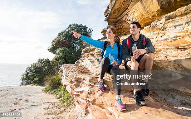 couple hiking and pointing away - rocky point stock pictures, royalty-free photos & images