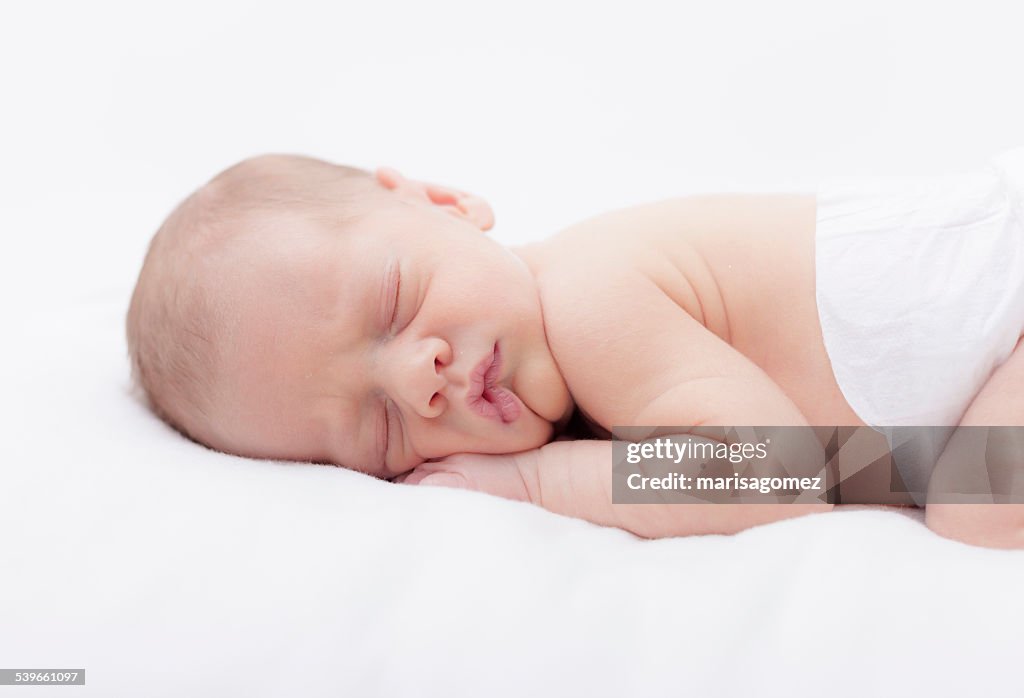 Newborn baby boy sleeping on stomach