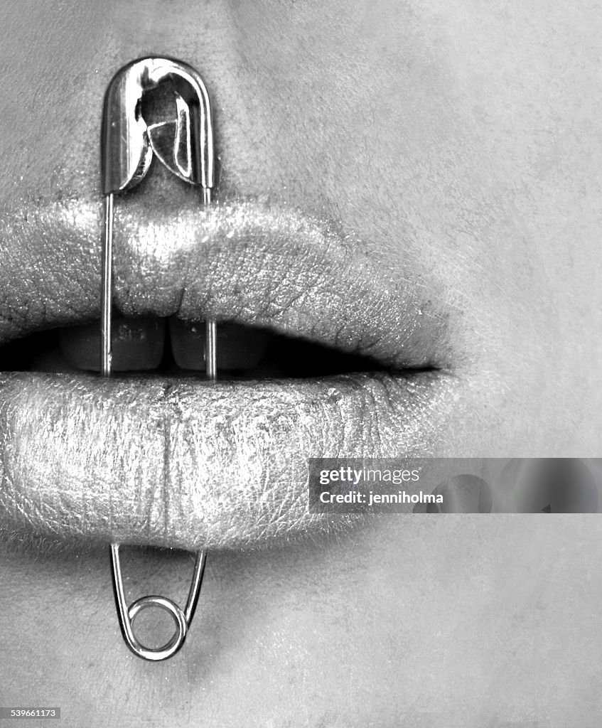 Safety pin through woman's lips