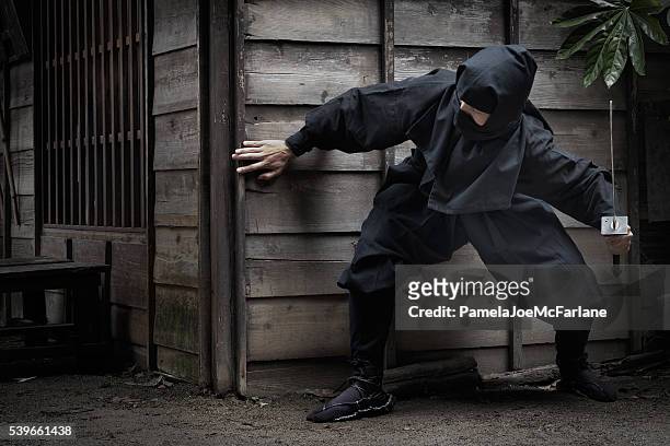 japanische ninja mit schwert verstecken hinter dem gebäude für ambush - ninja warrior stock-fotos und bilder