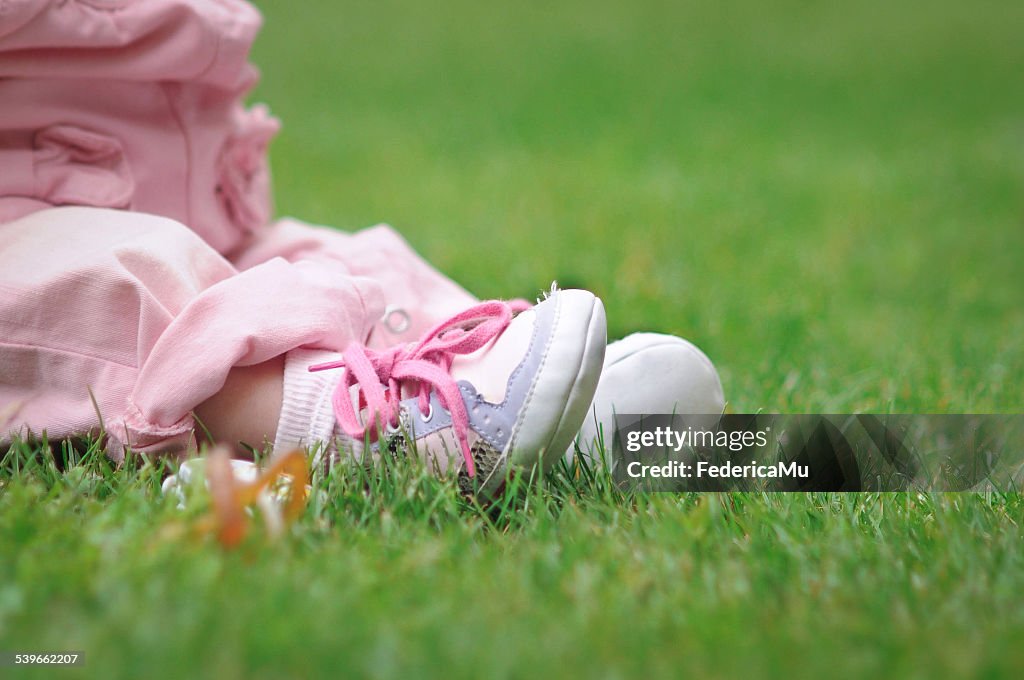 Low section of baby girl sitting on grass