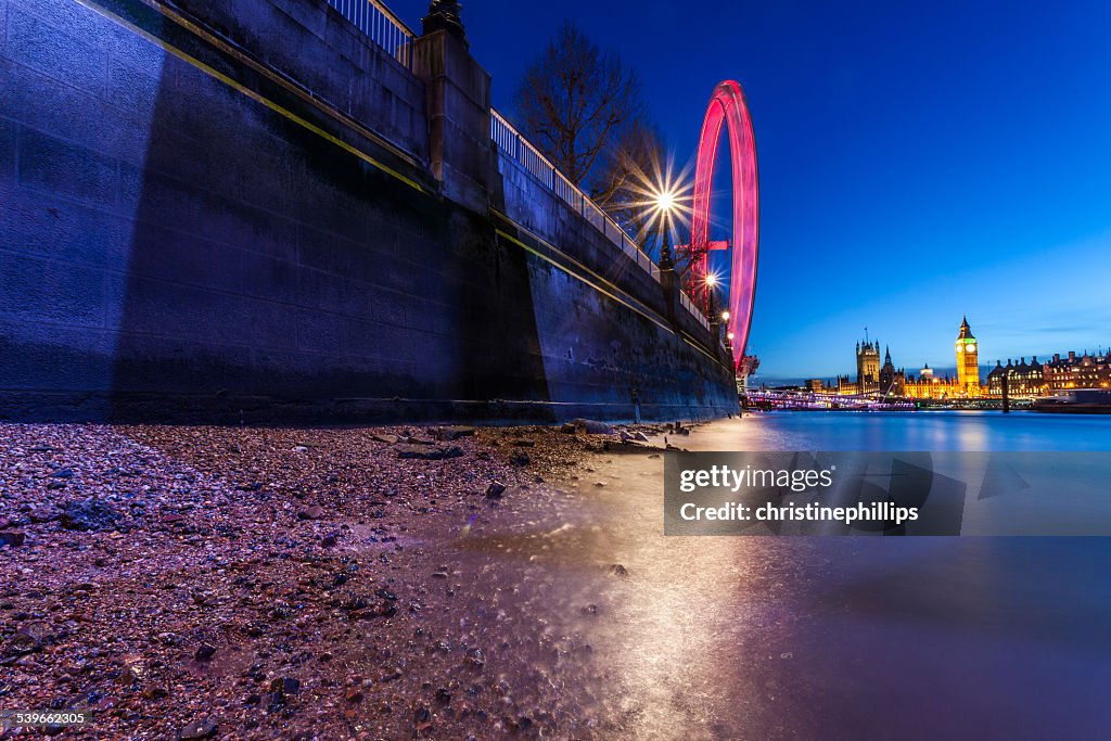 United Kingdom, England, London, Riverbank at night with city on background