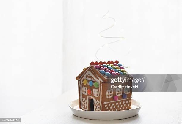 gingerbread house on plate - gingerbread house stock pictures, royalty-free photos & images