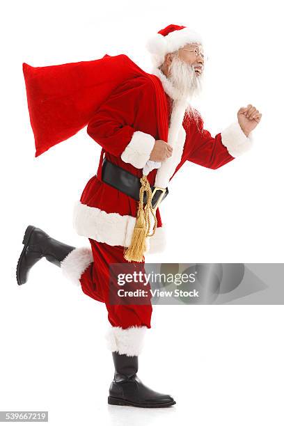 santa claus carrying sack of gifts - santa sack isolated stock pictures, royalty-free photos & images