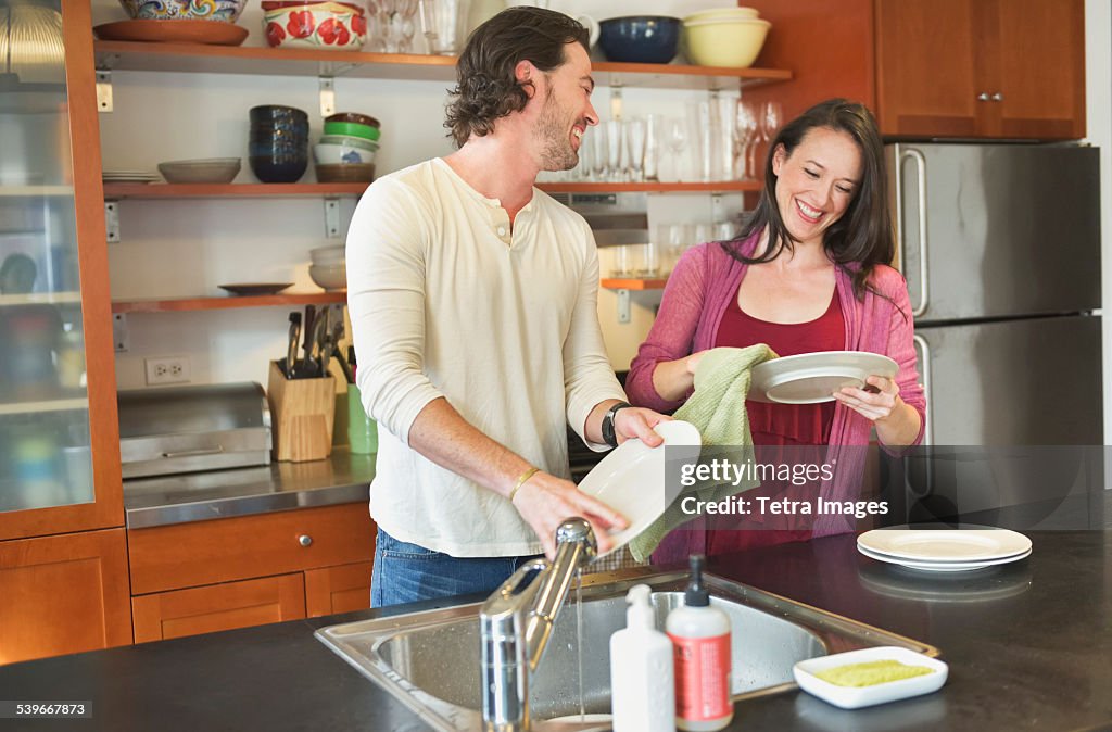 USA, New York State, New York City, Brooklyn, Happy couple washing dishes