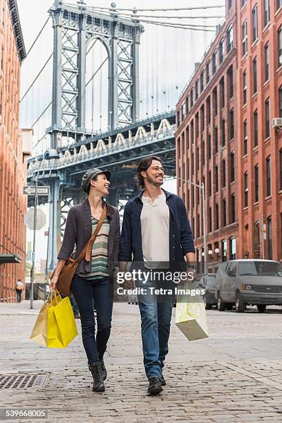 usa, new york state, new york city, brooklyn, couple walking on street, brooklyn bridge in background - touristen brooklyn bridge stock-fotos und bilder