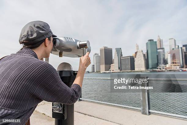 usa, new york state, new york city, brooklyn, woman watching cityscape through coin-operated binoculars - brooklyn bridge park 個照片及圖片檔