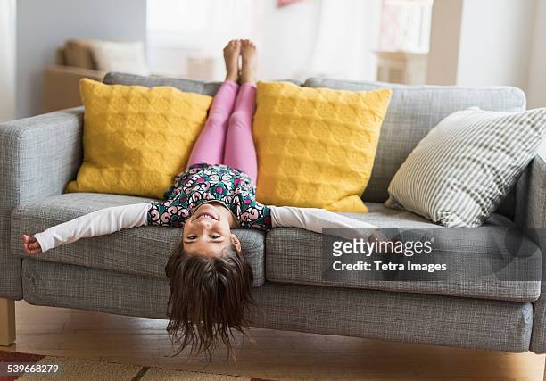 usa, new jersey, girl (6-7) lying upside down on sofa - barefoot feet up lying down girl stockfoto's en -beelden
