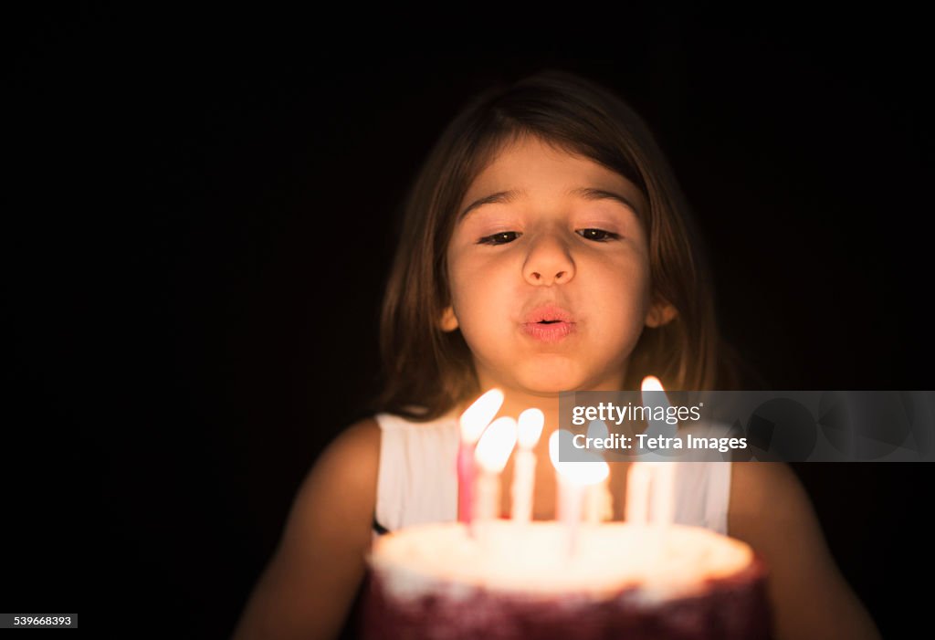 Portrait of girl (6-7) blowing out birthday candles