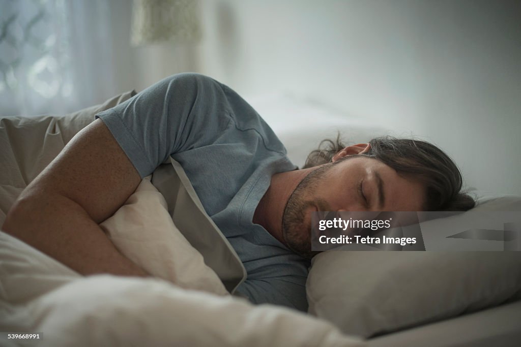USA, New Jersey, Man sleeping in bed