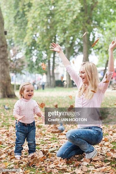 mother and daughter playing with leaves - mother of ian stock pictures, royalty-free photos & images