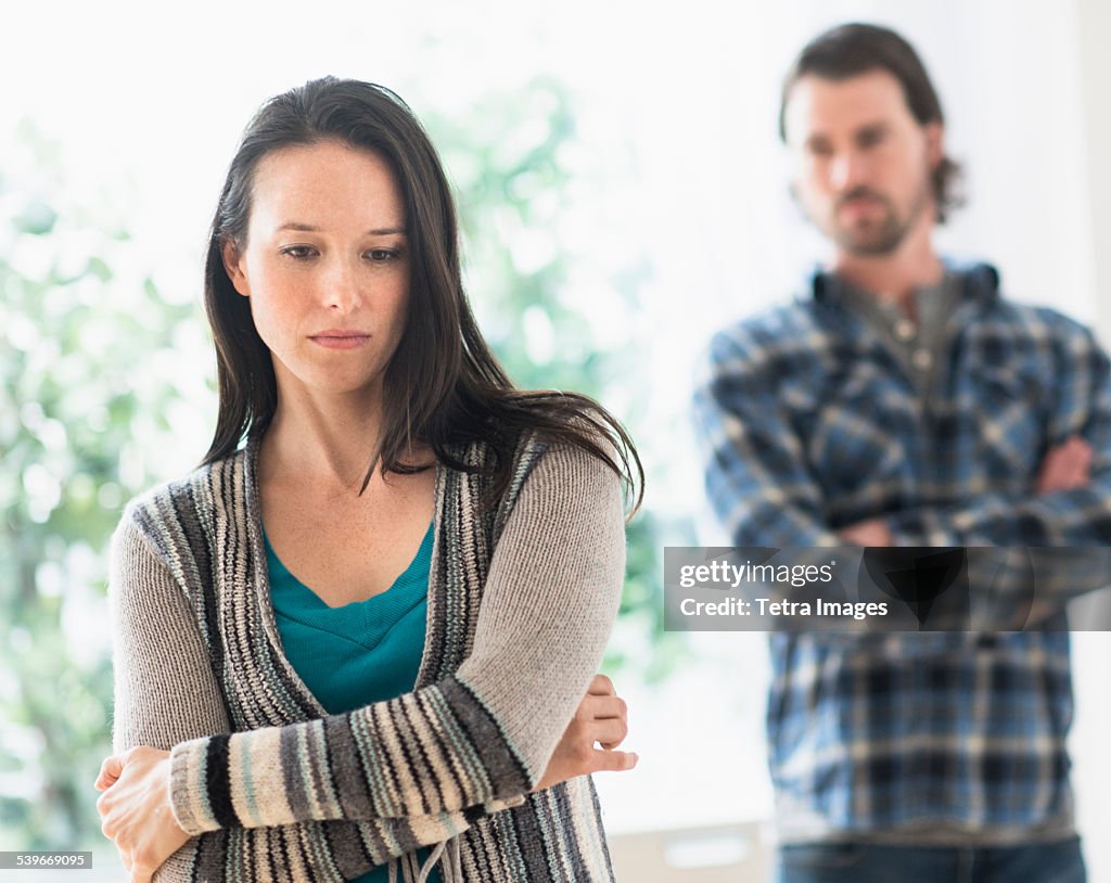 USA, New Jersey, Sad woman with arms crossed, man in background