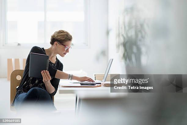 usa, new jersey, businesswoman using laptop in office - messa a fuoco differenziale foto e immagini stock