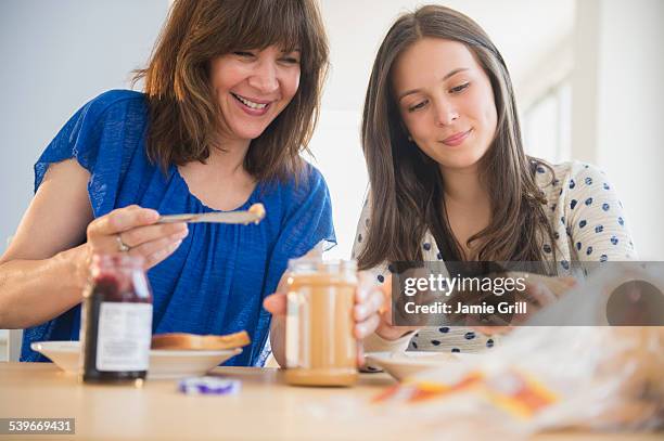 usa, new jersey, mother and daughter (14-15) making peanut butter and jelly sandwiches - peanut butter and jelly sandwich stock pictures, royalty-free photos & images