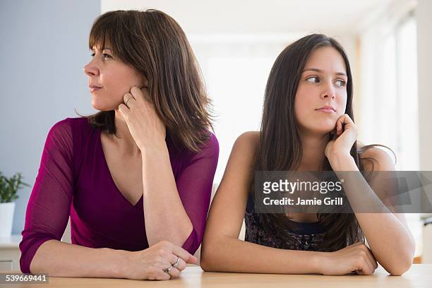 usa, new jersey, frustrated teenage girl (14-15) and her mom sitting at table - teens arguing stock pictures, royalty-free photos & images