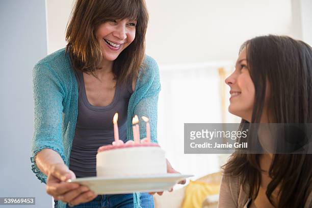 usa, new jersey, teenage girl (14-15) celebrating birthday with her mom at home - holding birthday cake stock pictures, royalty-free photos & images