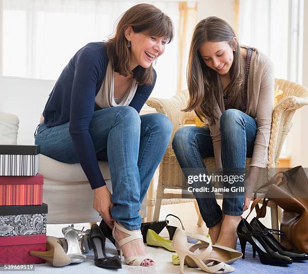 usa, new jersey, teenage girl (14-15) sitting with her mom and trying on high heels - family shoes stockfoto's en -beelden