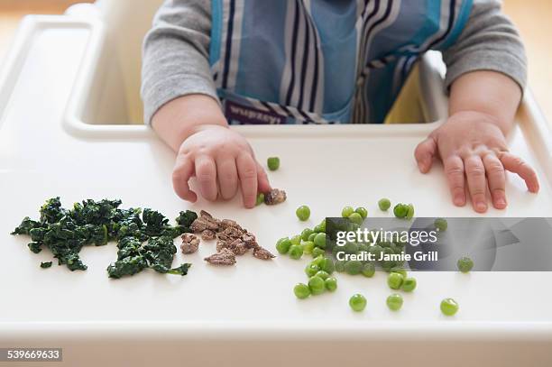 baby girl (12-17 months) eating steak, spinach and green peas - fresh baby spinach stock-fotos und bilder