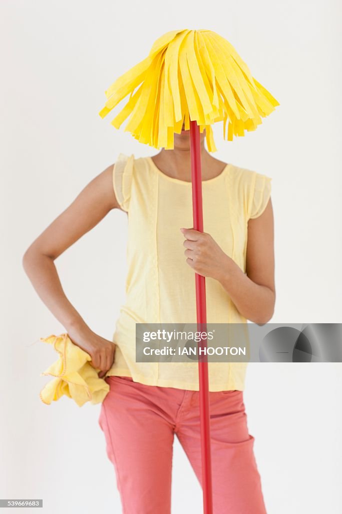 Woman holding mop in front of face