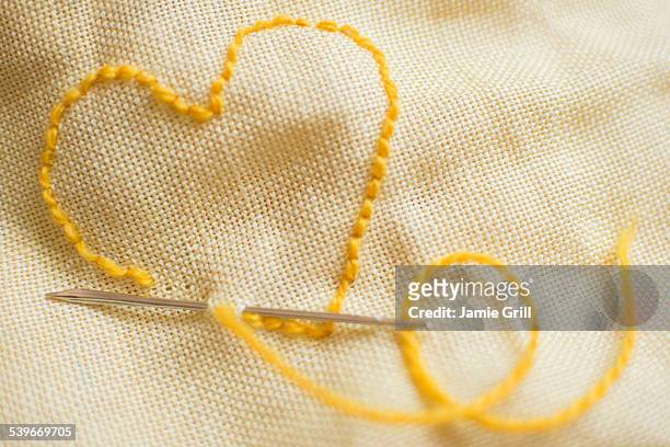 stitched yellow heart - sewing needle stock pictures, royalty-free photos & images