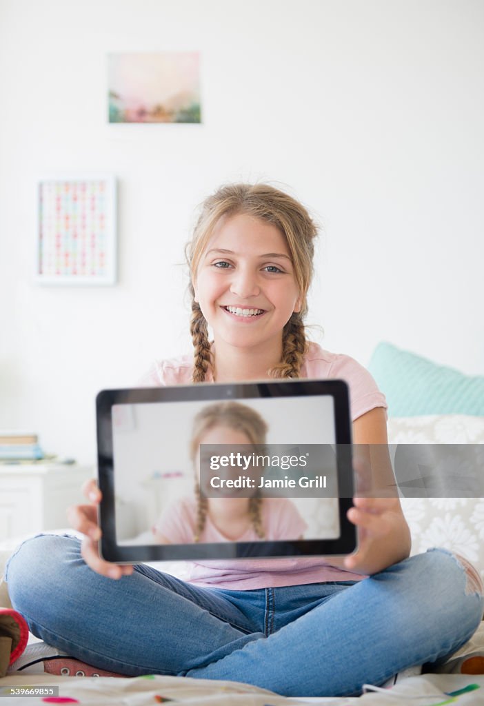 USA, New Jersey, Girl (12-13) holding tablet with selfie