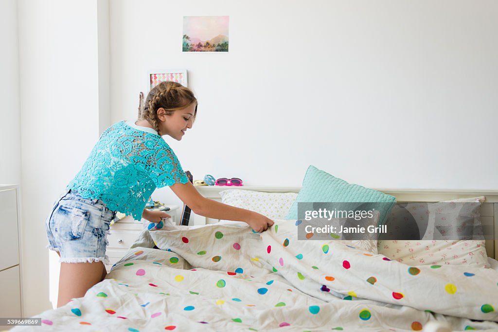 USA, New Jersey, Girl (12-13) making bed