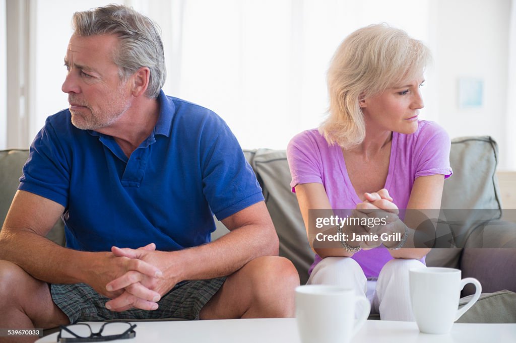 USA, New Jersey, Portrait of couple sitting on sofa, looking away from each other