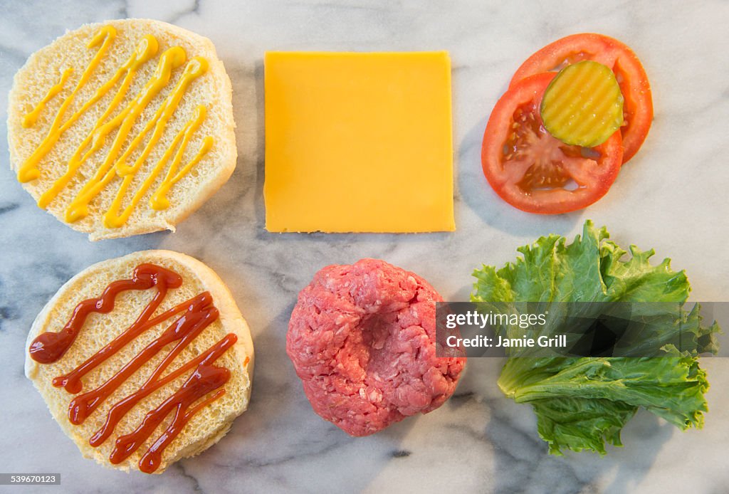 Close-up shot of hamburger ingredients in rows on table