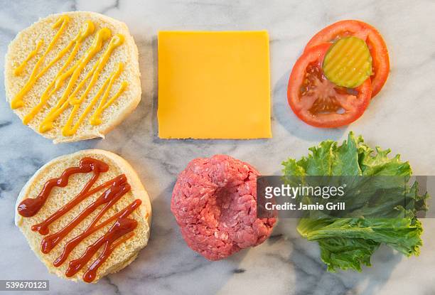 close-up shot of hamburger ingredients in rows on table - burgers cooking grill stockfoto's en -beelden