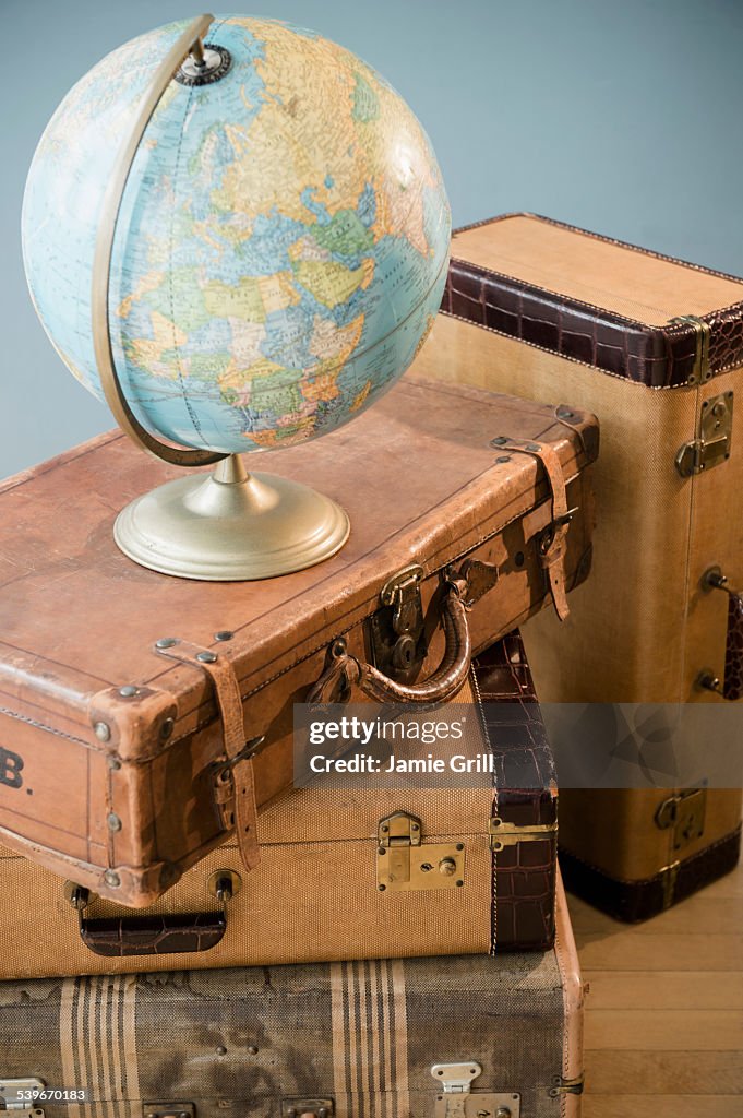Studio shot of globe on suitcases