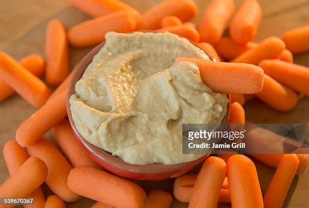 studio shot of hummus and baby carrots - ベビーキャロット ストックフォトと画像