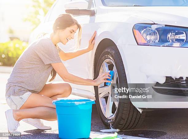 usa, florida, jupiter, portrait of young woman washing white car - daily bucket foto e immagini stock