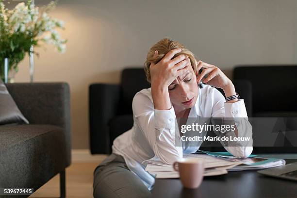 netherlands, brabant, breda, portrait of sad woman using mobile phone - head in hands stock pictures, royalty-free photos & images