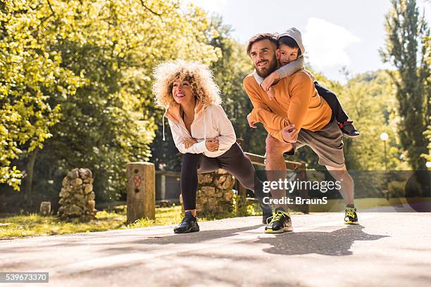 young happy family doing stretching exercises in the park. - family exercising stock pictures, royalty-free photos & images