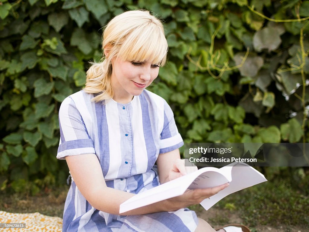 USA, Utah, Salt Lake City, Woman reading book in garden