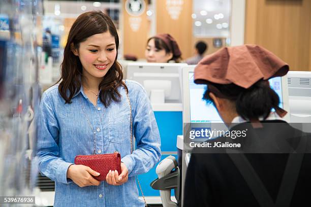 woman at the checkout of a supermarket - checkout aisle stock pictures, royalty-free photos & images