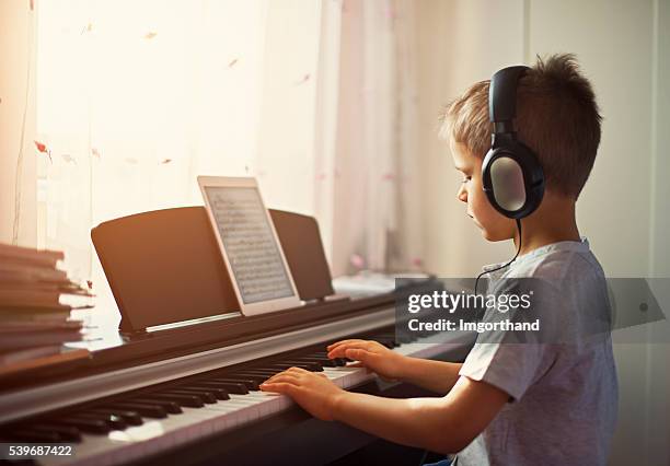 little boy practicing modern digital piano. - pianist stockfoto's en -beelden