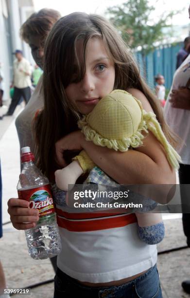Amanda Malloy from Metairie, Louisiana, hugs a stuffed doll given to her by a Red Cross volunteer before entering a shelter at the River Center on...