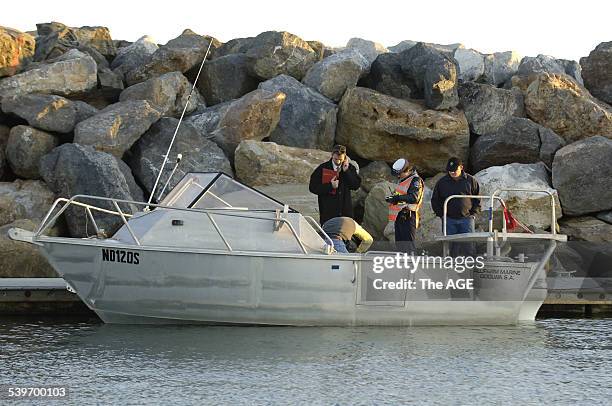 Police examine the boat that was used by the divers when one of them was taken by a shark about 2km off shore from Glenelg. Tuesday 24 August 2005...