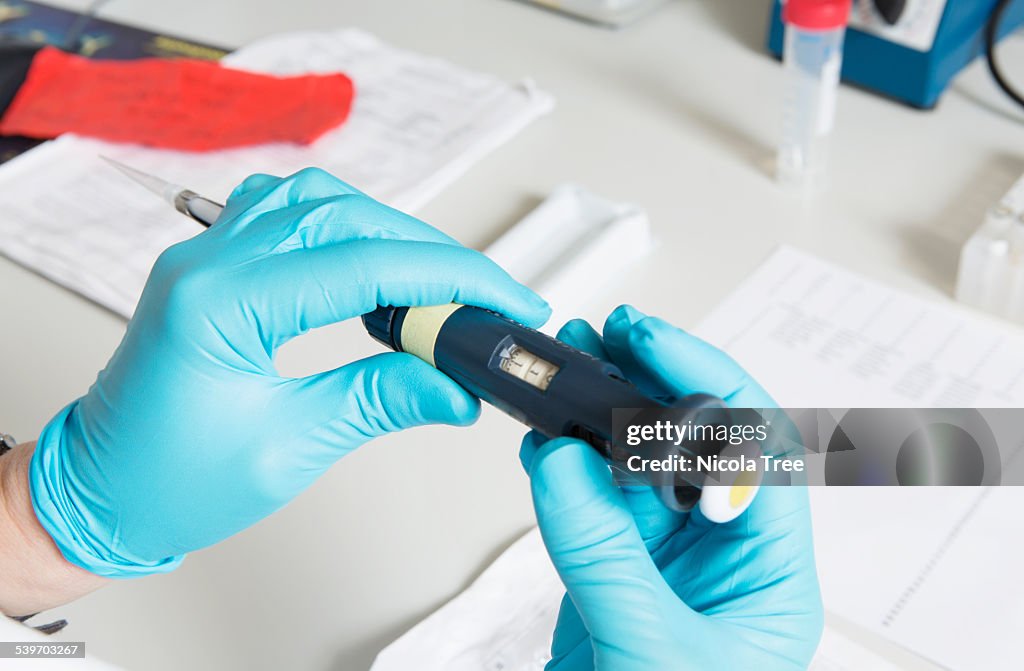 Lab researcher adjusting a pipette