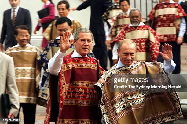 Russian President Vladimir Putin and United States President George Bush wave as leaders from the Pacific Rim pose for a photocall wearing the...