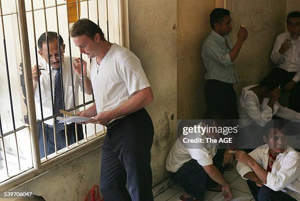 Martin Stephens talks to his lawyer through the bars of the holding cell, 19th October 2005, THE AGE Picture by JASON SOUTH