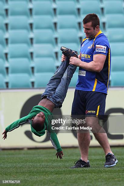 Parramatta Eels player, Justin Poore, plays with Nathan Sengoga from Rwanda. Nathan is in Australia for the Hope Rwanda Charity. Picture taken during...