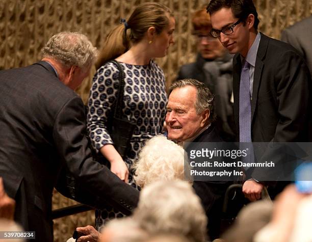 Former president George H.W. Bush is greeted as he hears Defense Secretary Robert Gates talk about his new book, "Duty" that criticizes many Bush and...