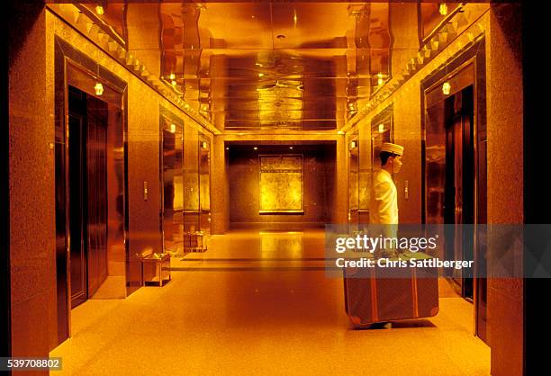 bellhop with suitcases waiting for elevator - bellhop stock pictures, royalty-free photos & images