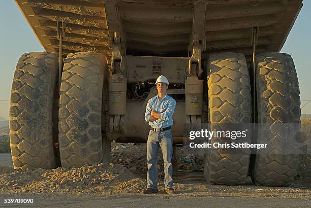 construction worker standing near dump truck - construction vehicle stock pictures, royalty-free photos & images