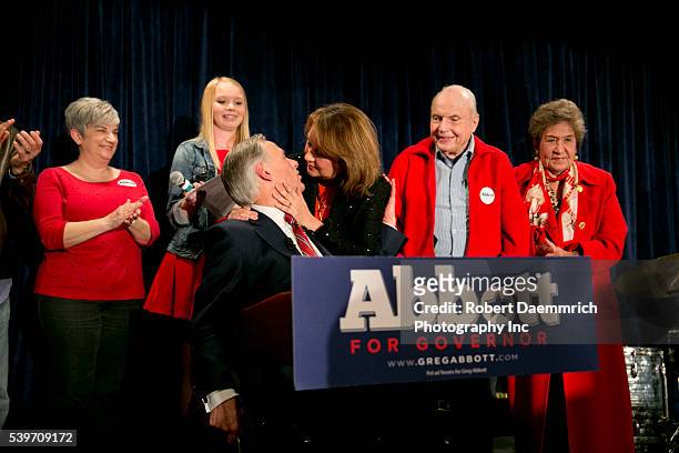 Texas Attorney General Greg Abbott gets a kiss from wife Cecilia after addressing supporters at Aldaco's Mexican Cafe after winning the Republican...