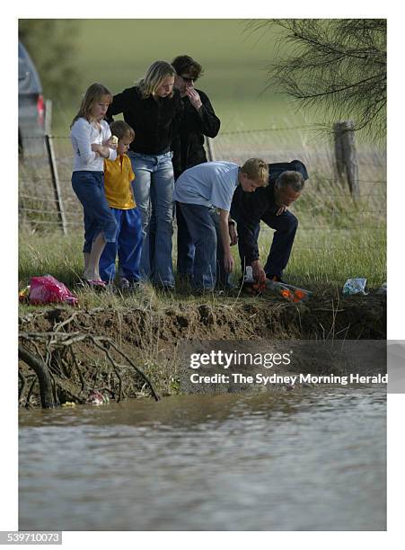 Friends grieve at the site near Winchlesea where a father's car left the road crashing into a dam, killing his three sons, 5 September 2005. SMH...