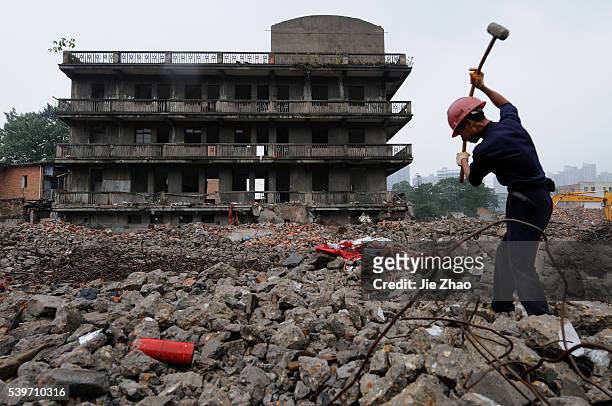 Man searches for recyclable reinforcing steel at a demolition site to make way for a new residential area in Nanchang, Jiangxi province September 27,...