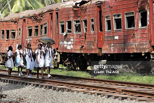 Schoolgirls walk past train carriages which were hit by the tsunami in Sri Lanka. More than a 1000 passengers on the train were killed by the wave....